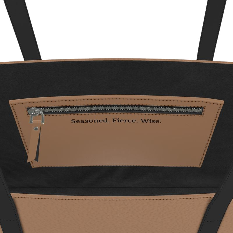 Close-up of a black and brown bag with text 'Seasoned. Fierce. Wise.' on brown small tote
