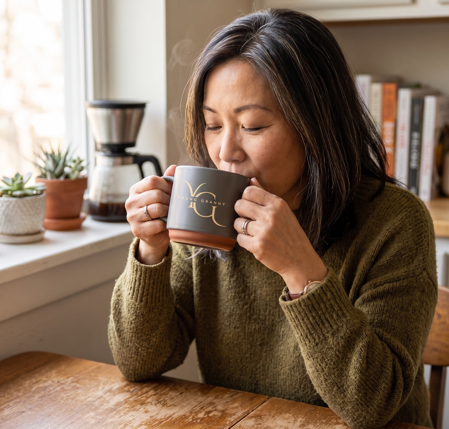 Woman drinking from an ash YG mug in a cozy kitchen setting